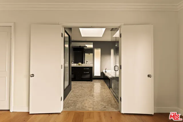 a view of a hallway with wooden floor and a living room