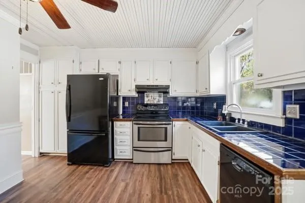 a kitchen with granite countertop a refrigerator stove and sink