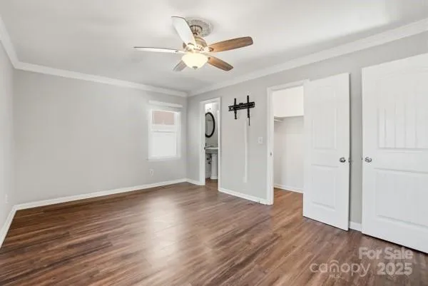 an empty room with wooden floor and a ceiling fan