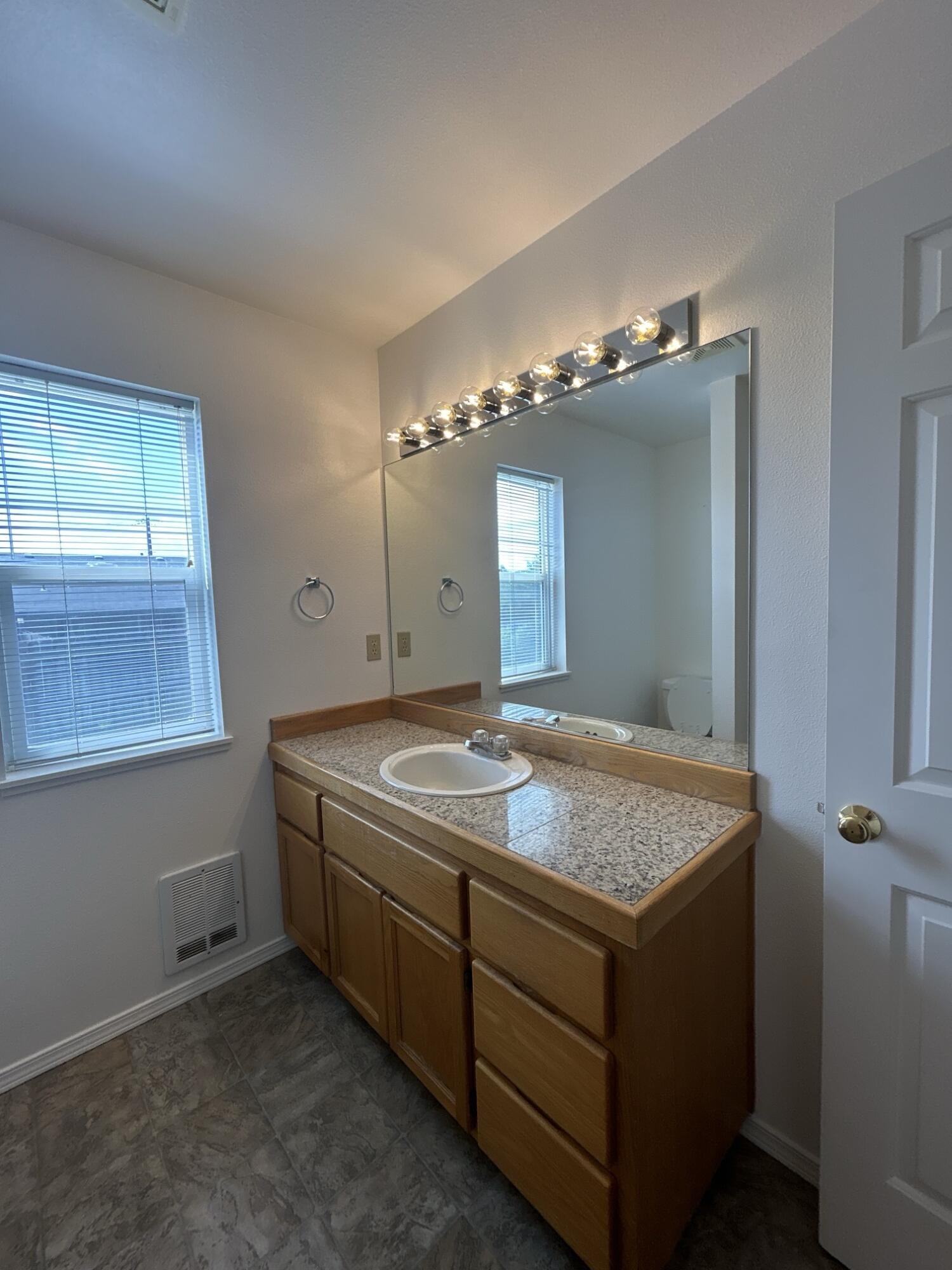 2211 Southwest Quartz Avenue Redmond, OR 97756 - Photo 8 of 26 a bathroom with a granite countertop sink and a mirror
