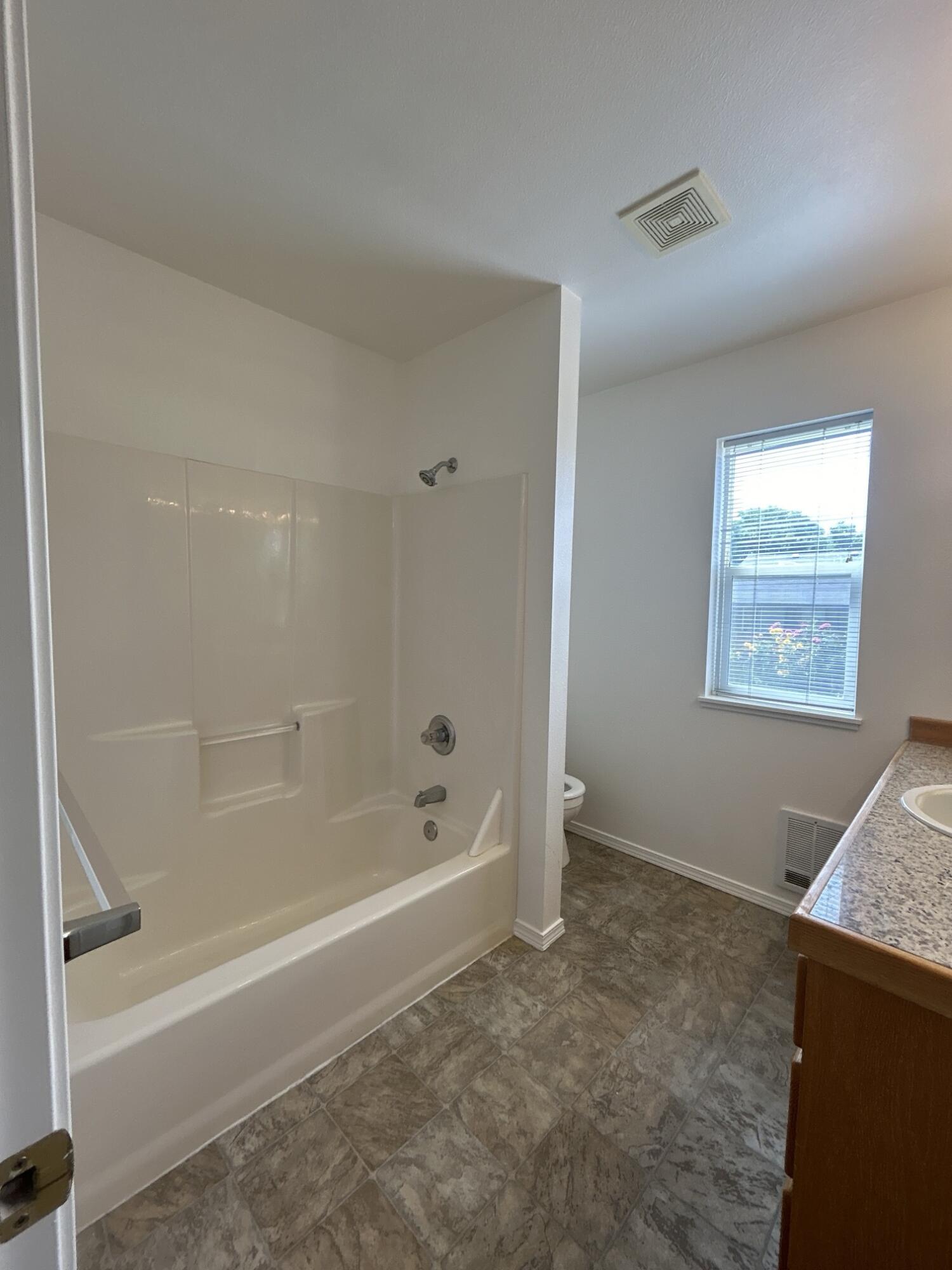 2211 Southwest Quartz Avenue Redmond, OR 97756 - Photo 9 of 26 a white bath tub sitting next to a window