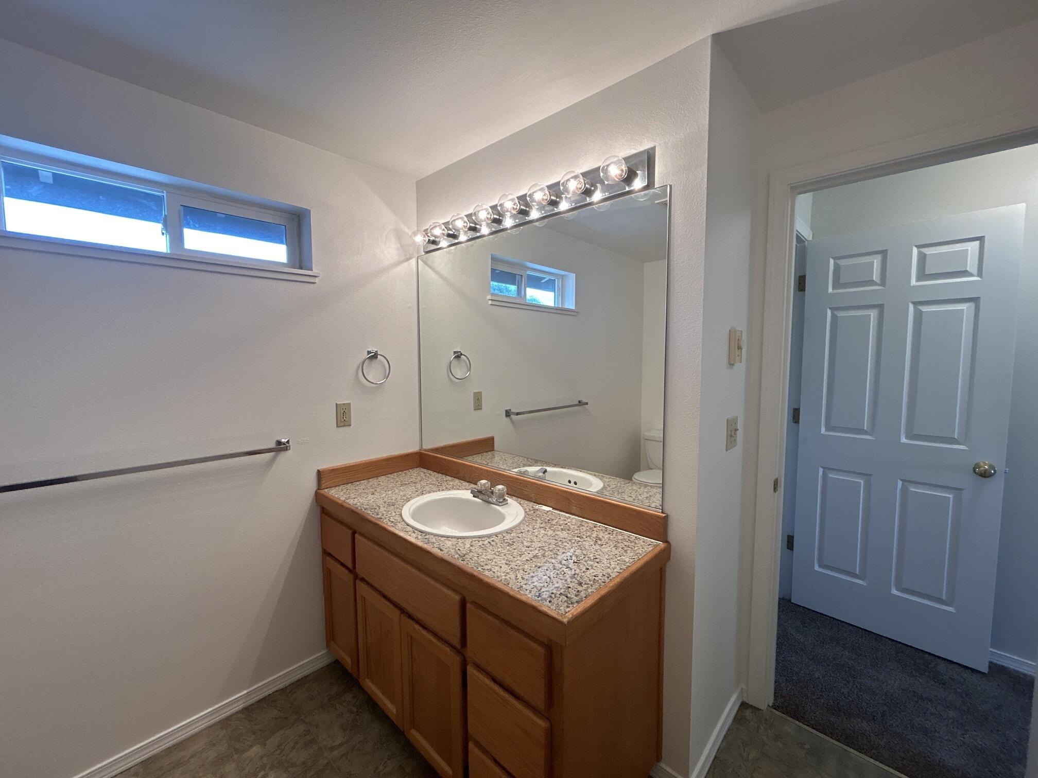 2211 Southwest Quartz Avenue Redmond, OR 97756 - Photo 13 of 26 a bathroom with a granite countertop sink and a mirror
