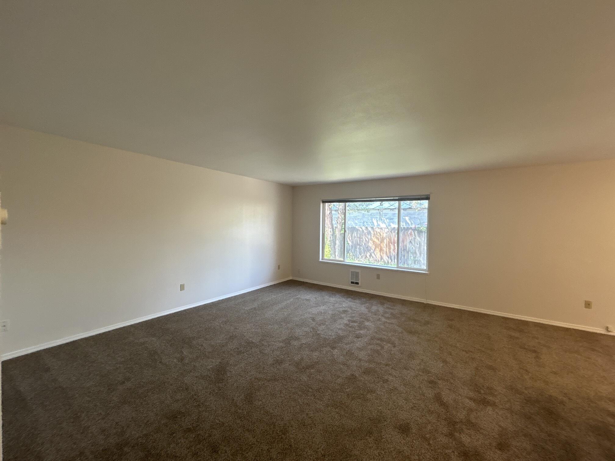 2211 Southwest Quartz Avenue Redmond, OR 97756 - Photo 5 of 26 an empty room with a windows and fireplace