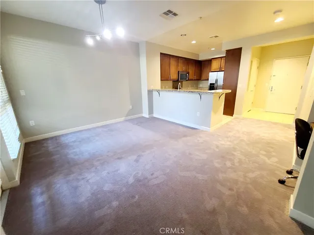 an empty room with a bathroom and a window