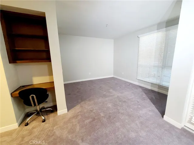 an empty room with windows and cabinet