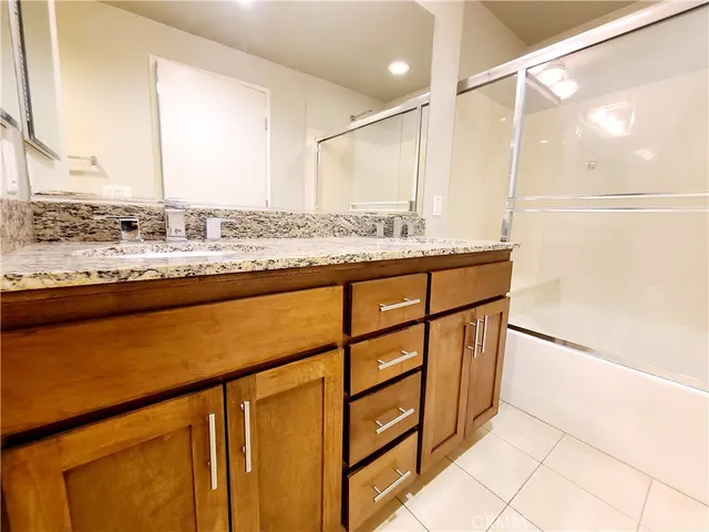 a bathroom with a granite countertop sink and a toilet