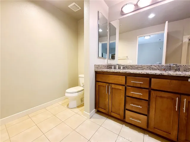 a bathroom with a granite countertop sink mirror toilet shower and bathtub