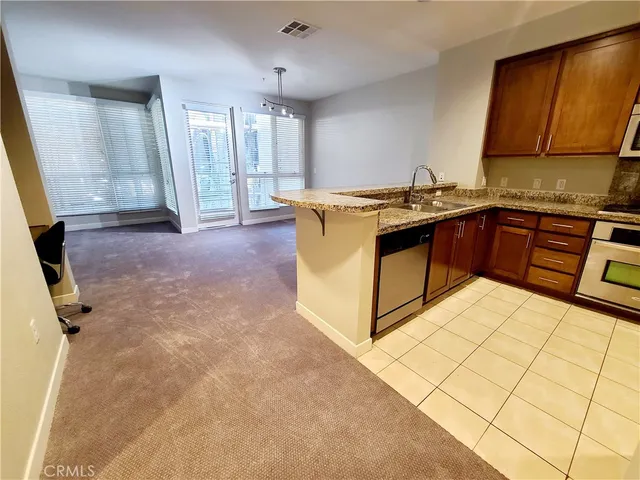 a kitchen with stainless steel appliances granite countertop a sink stove and cabinets
