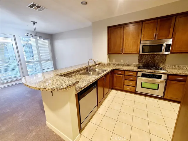 a kitchen with granite countertop wooden cabinets and stainless steel appliances