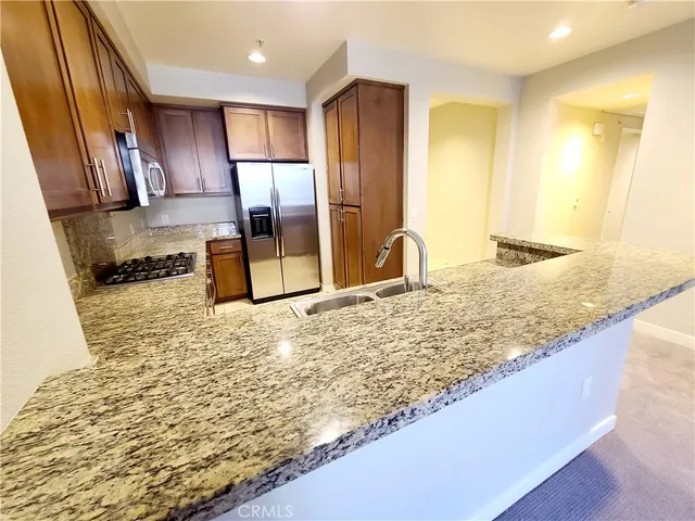 a kitchen with stainless steel appliances granite countertop a sink and a stove