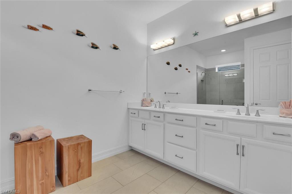 14662 Catamaran Place Naples, FL 34114 - Photo 17 of 44 a bathroom with double vanity sink and mirror