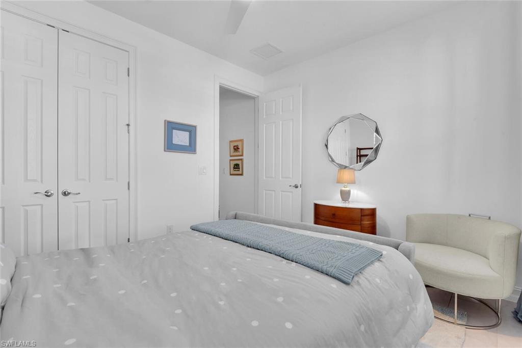 14662 Catamaran Place Naples, FL 34114 - Photo 21 of 44 a bedroom with a bed and a chandelier