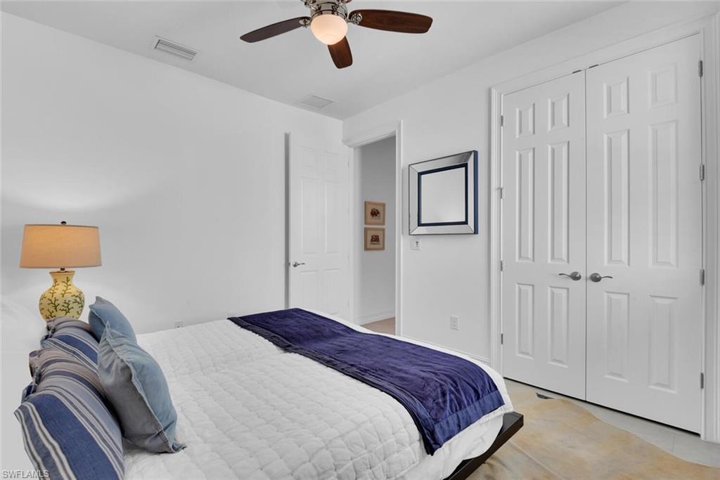 14662 Catamaran Place Naples, FL 34114 - Photo 24 of 44 a bedroom with a bed and a lamp