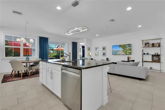 a kitchen with granite countertop a sink and white cabinets