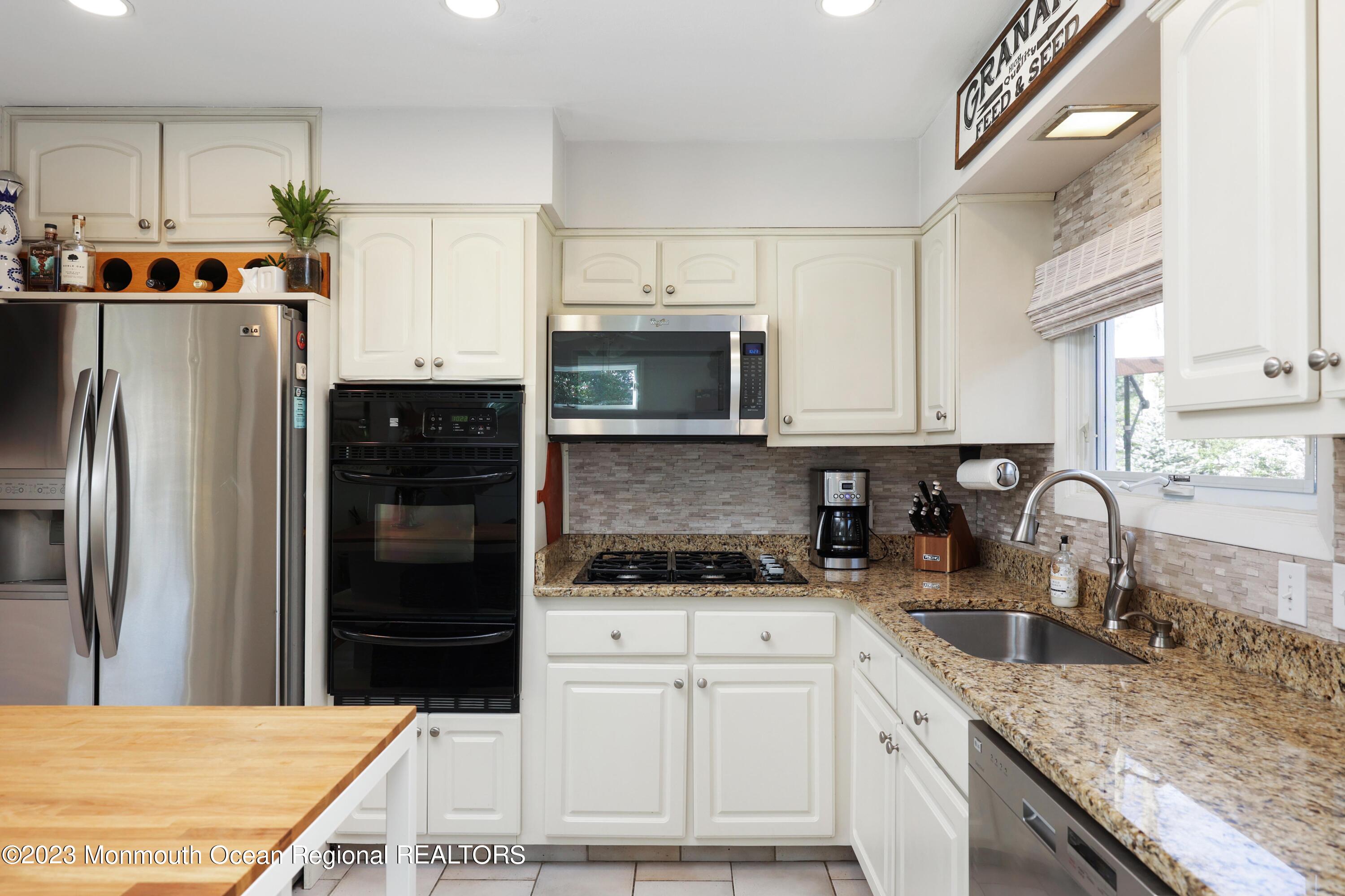 1208 Oak Road Manasquan, NJ 08736 - Photo 19 of 52 a kitchen with granite countertop a refrigerator stove and sink