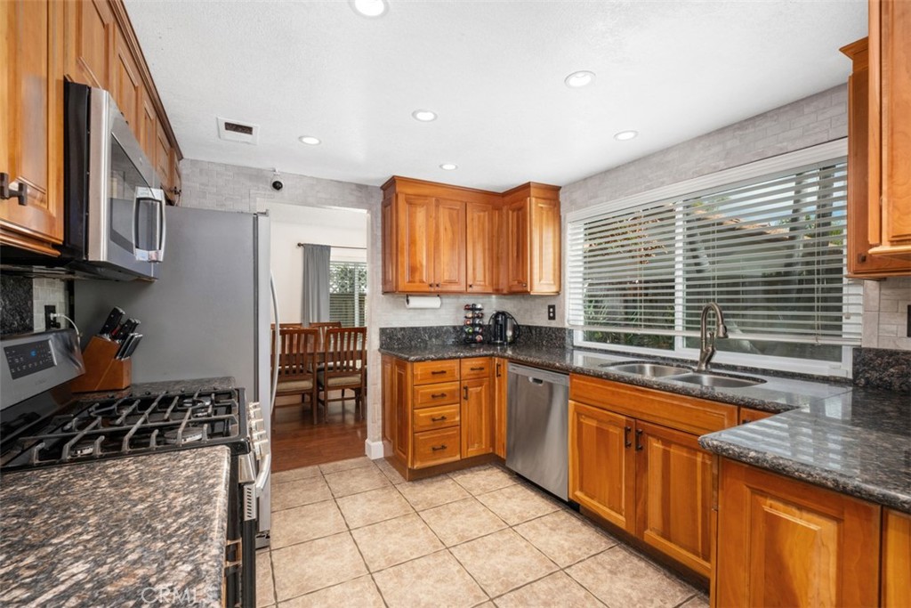 4 Firethorn Rancho Santa Margarita, CA 92688 - Photo 7 of 27 a kitchen with stainless steel appliances granite countertop a stove a sink and a microwave