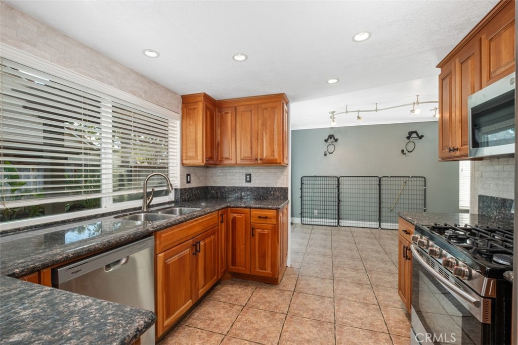4 Firethorn Rancho Santa Margarita, CA 92688 - Photo 9 of 27 a kitchen with stainless steel appliances granite countertop a sink stove and cabinets