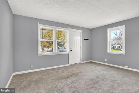 an empty room with windows and closet