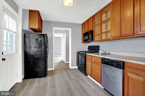 a kitchen with stainless steel appliances granite countertop a refrigerator a stove top oven a sink and dishwasher