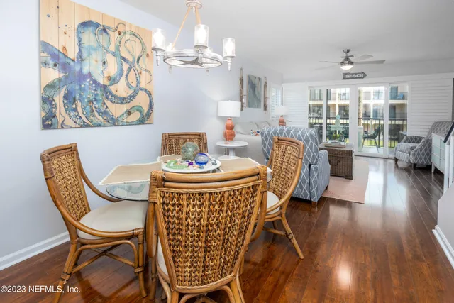 a dining room with furniture a chandelier and wooden floor