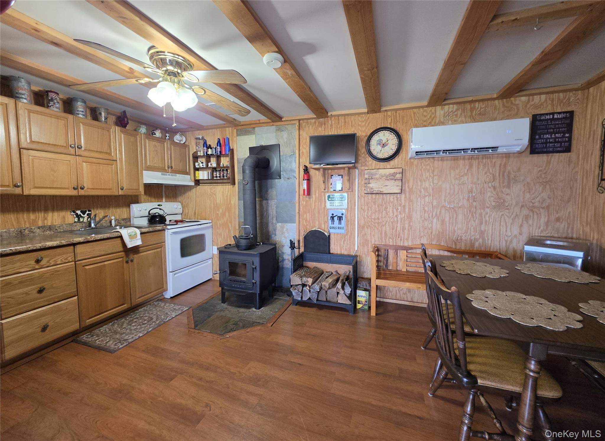 48 Mullen Road Parksville, NY 12768 - Photo 15 of 35 a kitchen with stainless steel appliances granite countertop a sink a stove a dining table and chairs with wooden floor