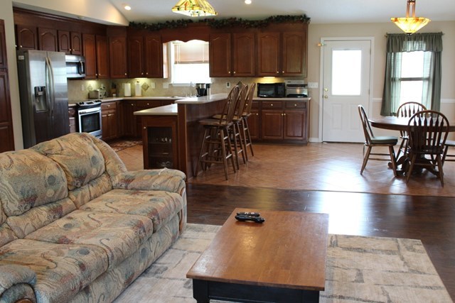 7164 Goodall Mill Road Macon, GA 31216 - Photo 5 of 12 a kitchen with stainless steel appliances granite countertop a refrigerator a stove a sink a dining table and chairs with wooden floor