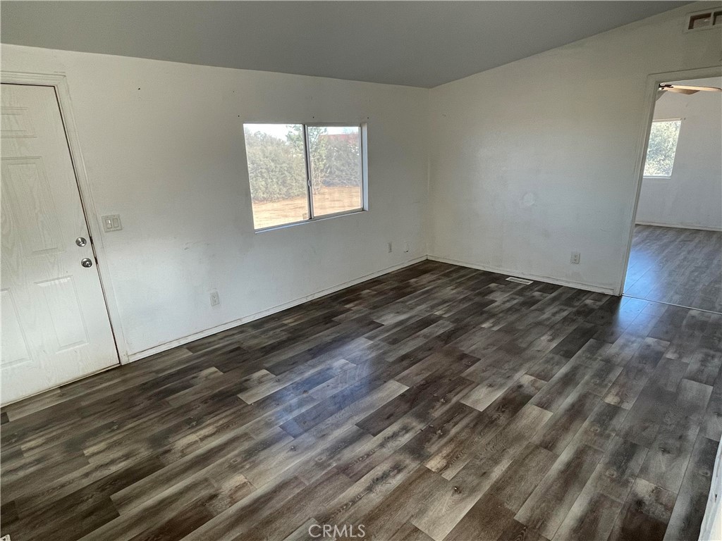 8354 White Road Phelan, CA 92371 - Photo 28 of 43 a view of an empty room with wooden floor and a window