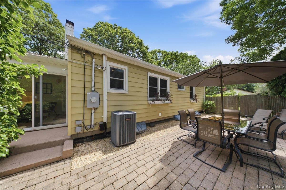 10 Graham Road Hampton Bays, NY 11946 - Photo 23 of 26 a view of a patio with table and chairs under an umbrella