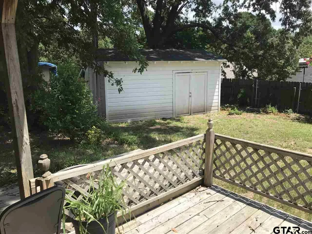 a view of a balcony with wooden floor and fence