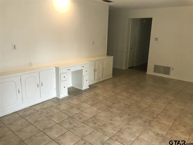 en empty room with windows and fireplace