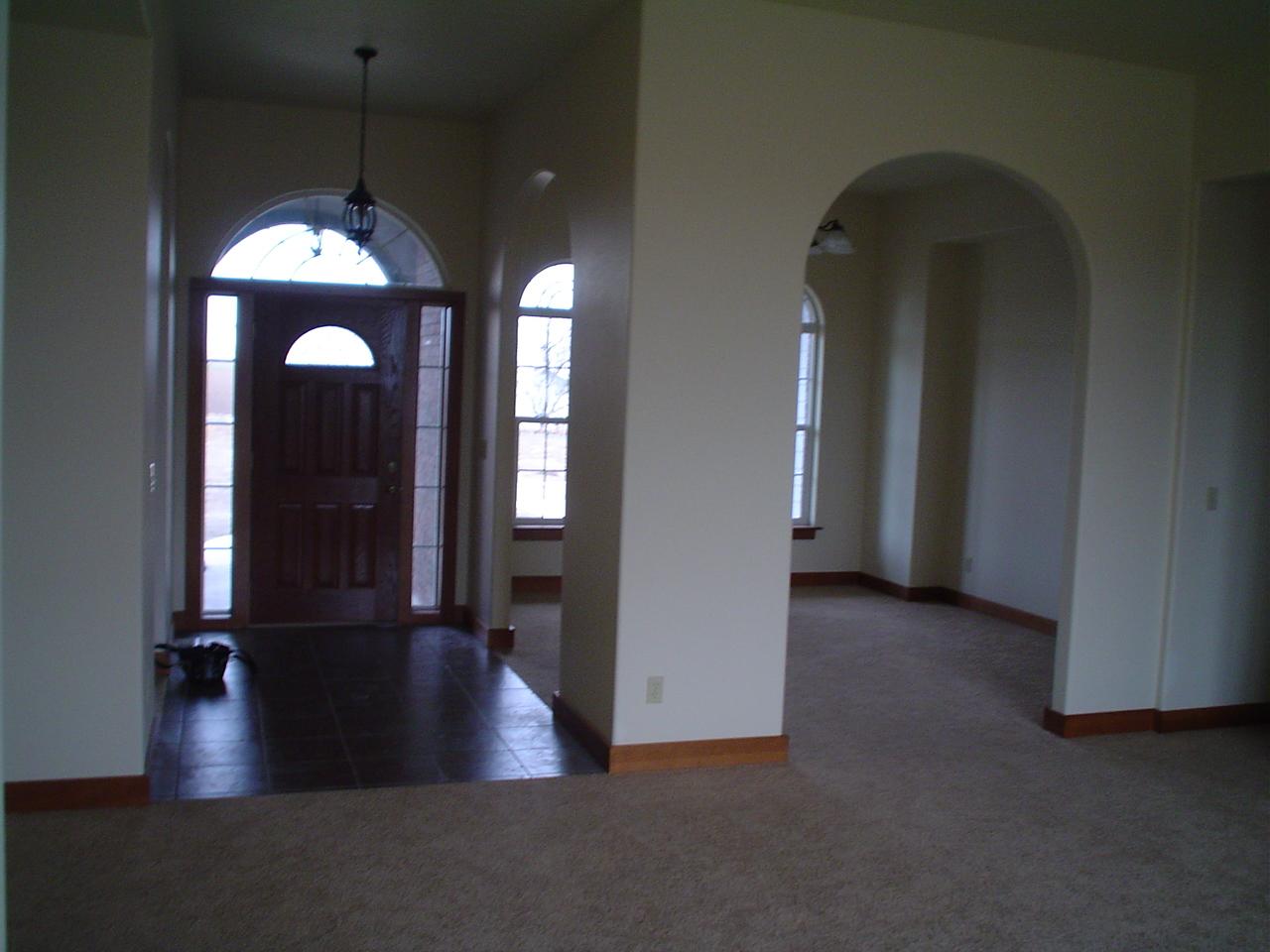 3141 Scoon Road Sunnyside, WA 98944 - Photo 7 of 9 an empty room with a chandelier fan and a large mirror