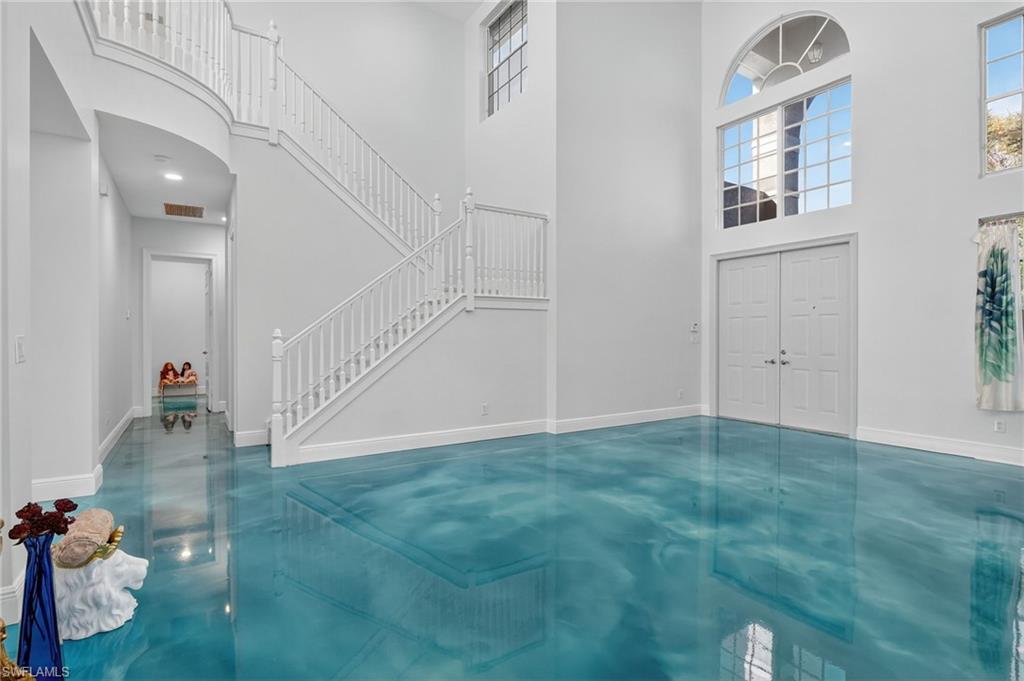 2234 Campestre Terrace Naples, FL 34119 - Photo 6 of 48 Foyer entrance featuring a towering ceiling, finished concrete floors, stairs, and plenty of natural light