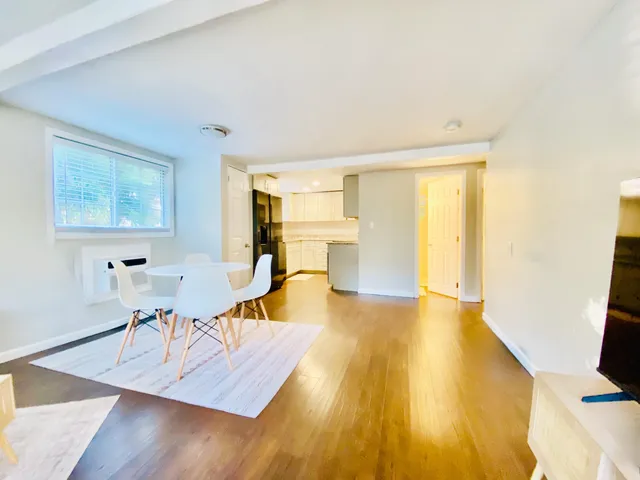 a view of a living room with furniture and wooden floor