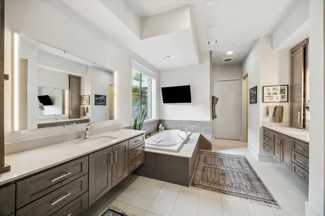 a spacious bathroom with a double vanity sink a mirror and shower