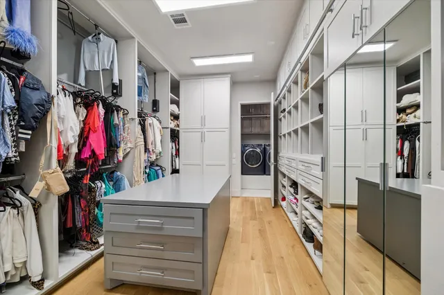 a view of walk in closet with clothes and shoes