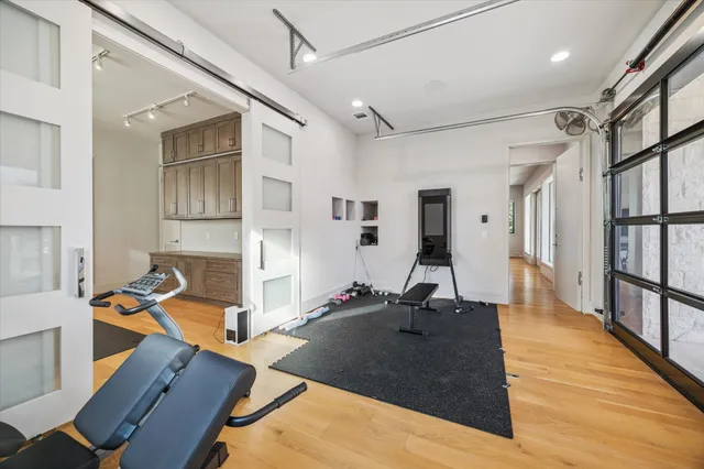 a room with gym equipment and wooden floor