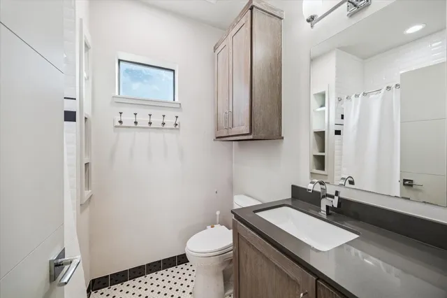 a bathroom with a sink a toilet and a mirror