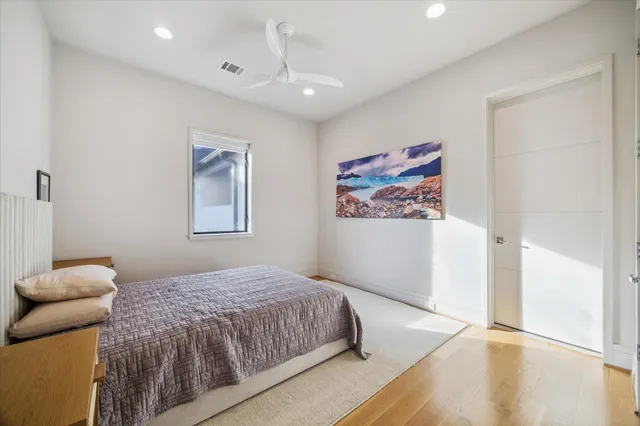 a bedroom with a large bed and a painting on the wall