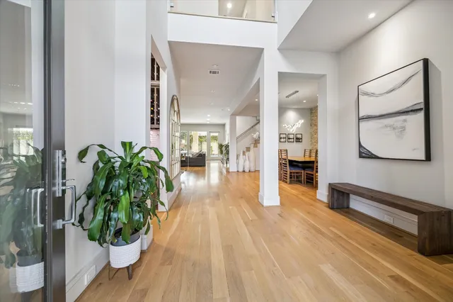 a view of a hallway with wooden floor and a potted plant
