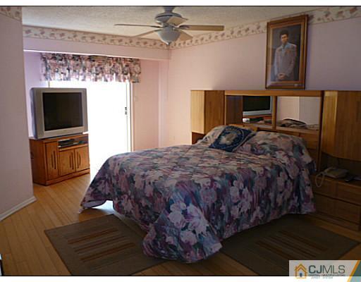 116 Almond Road Freehold, NJ 07728 - Photo 9 of 14 a spacious bedroom with a bed and a flat screen tv