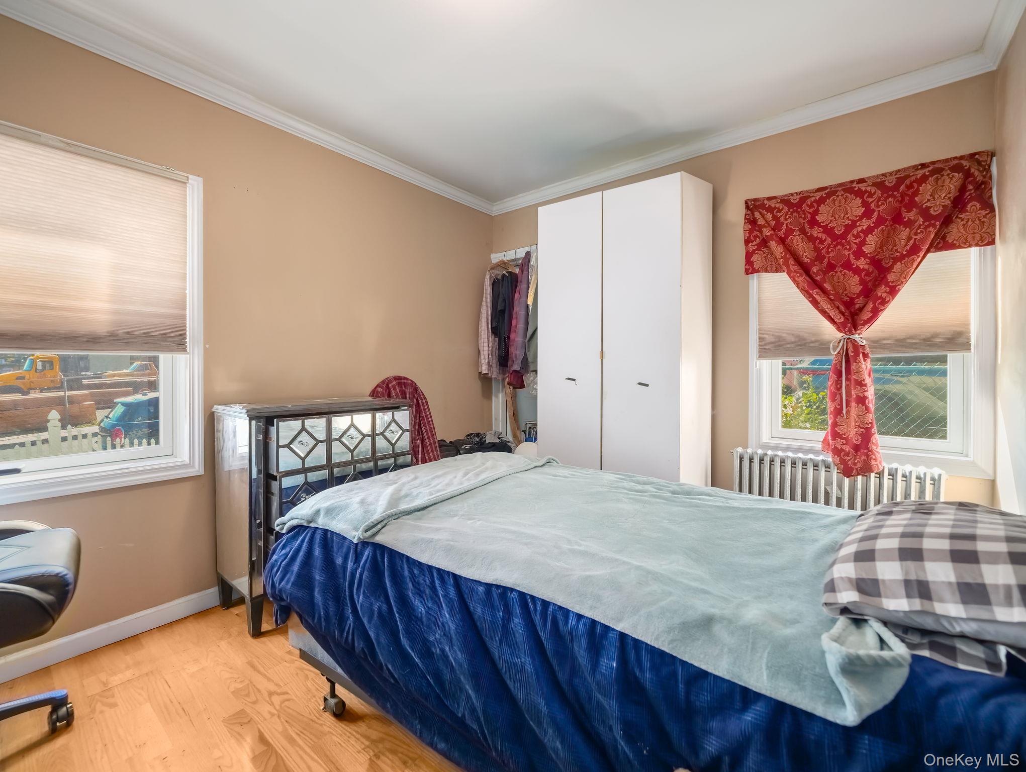 3 South Myrtle Avenue Spring Valley, NY 10977 - Photo 25 of 40 Bedroom featuring crown molding, light wood finished floors, radiator heating unit, and a closet