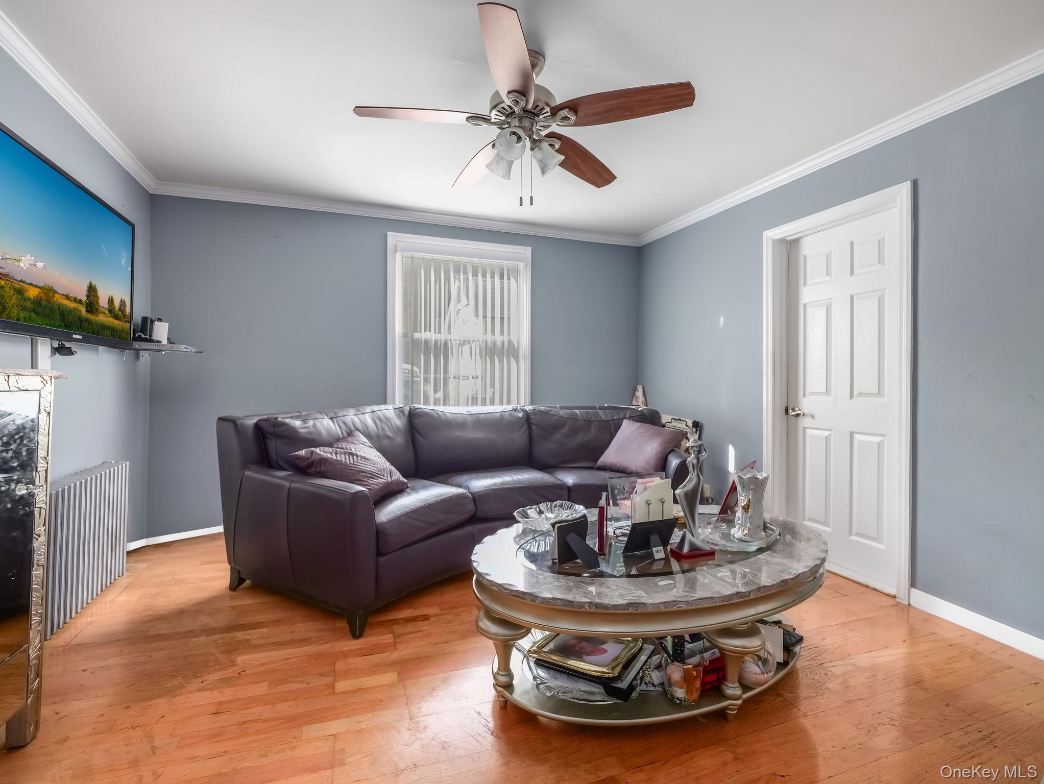 3 South Myrtle Avenue Spring Valley, NY 10977 - Photo 26 of 40 Living room featuring light wood-style floors, ornamental molding, and ceiling fan