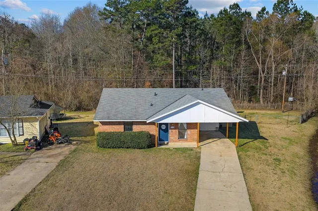 a front view of a house with a yard and trees