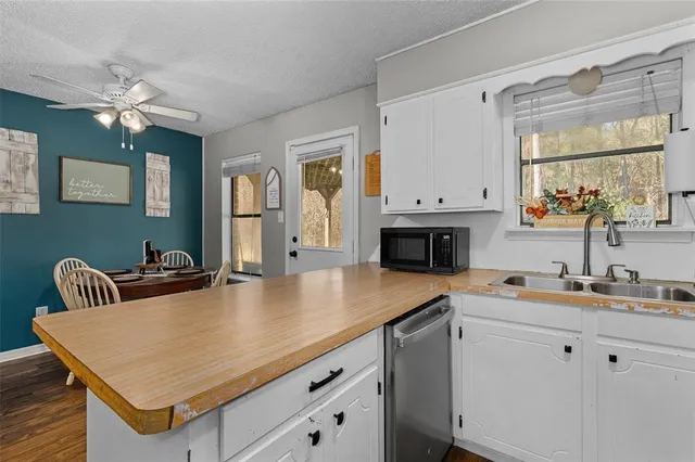 a kitchen with stainless steel appliances granite countertop a sink a stove and a table