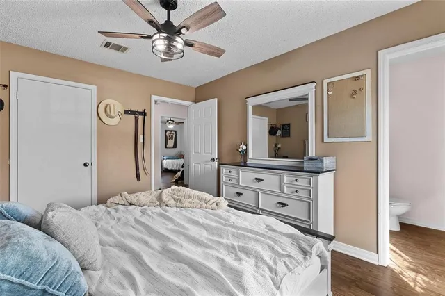 a bedroom with a bed a chandelier and a dresser