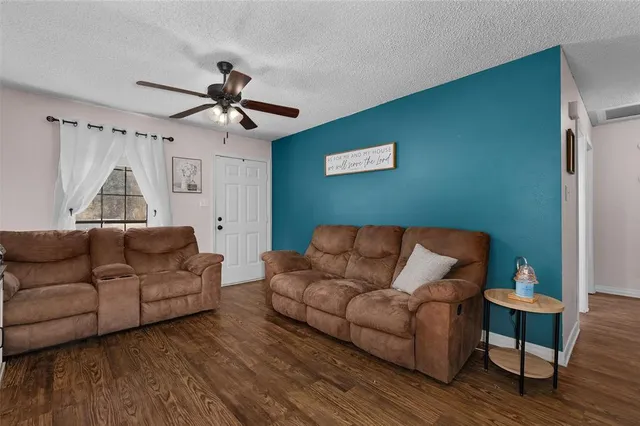 a living room with furniture and a wooden floor