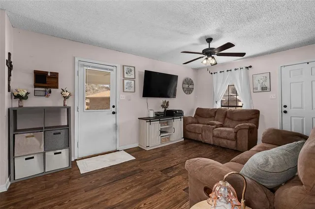 a living room with furniture a flat screen tv and kitchen view