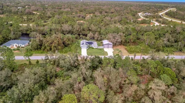 an aerial view of residential houses with outdoor space and trees