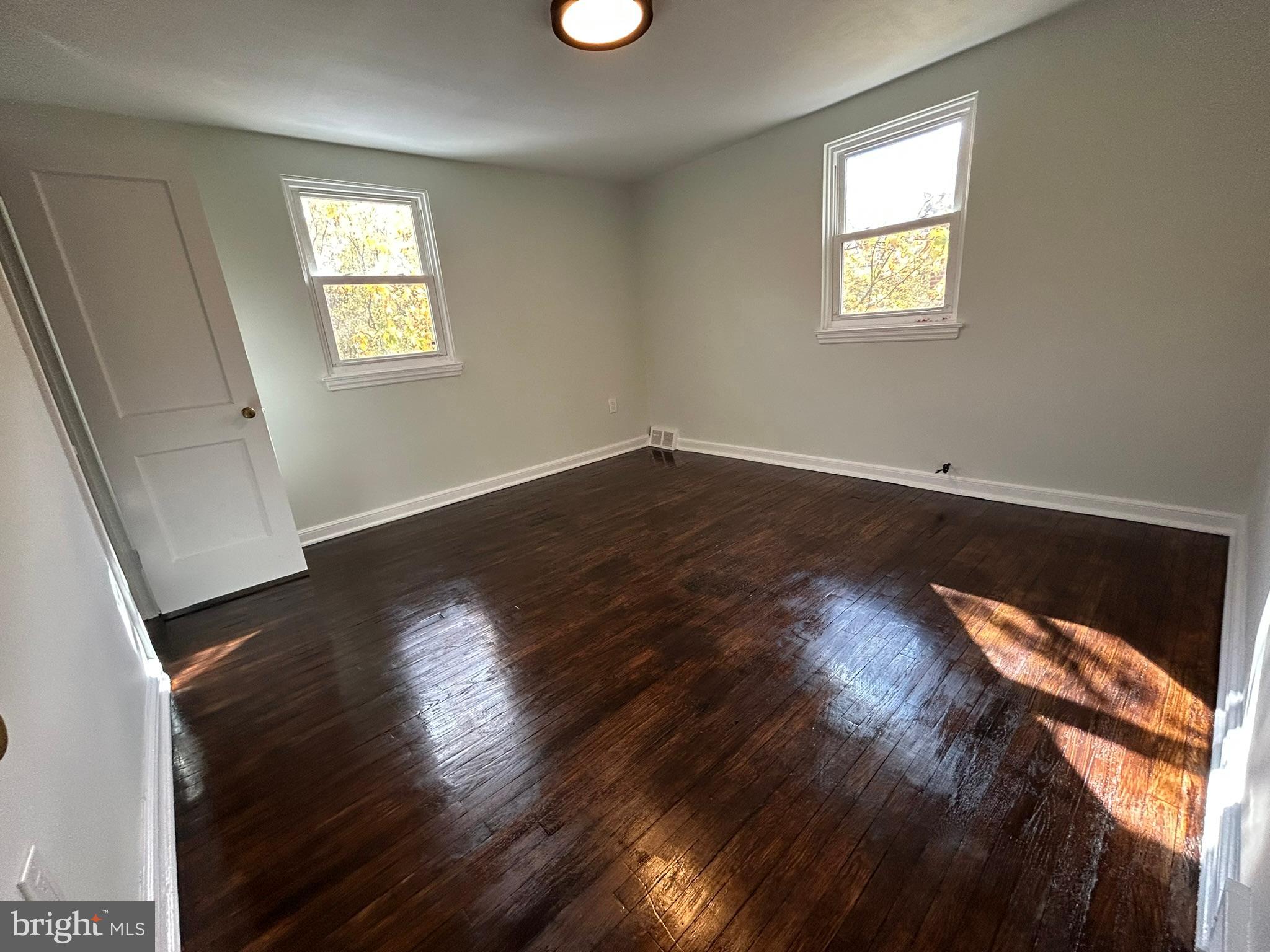 6643 Church Lane Upper Darby, PA 19082 - Photo 7 of 11 an empty room with wooden floor and windows