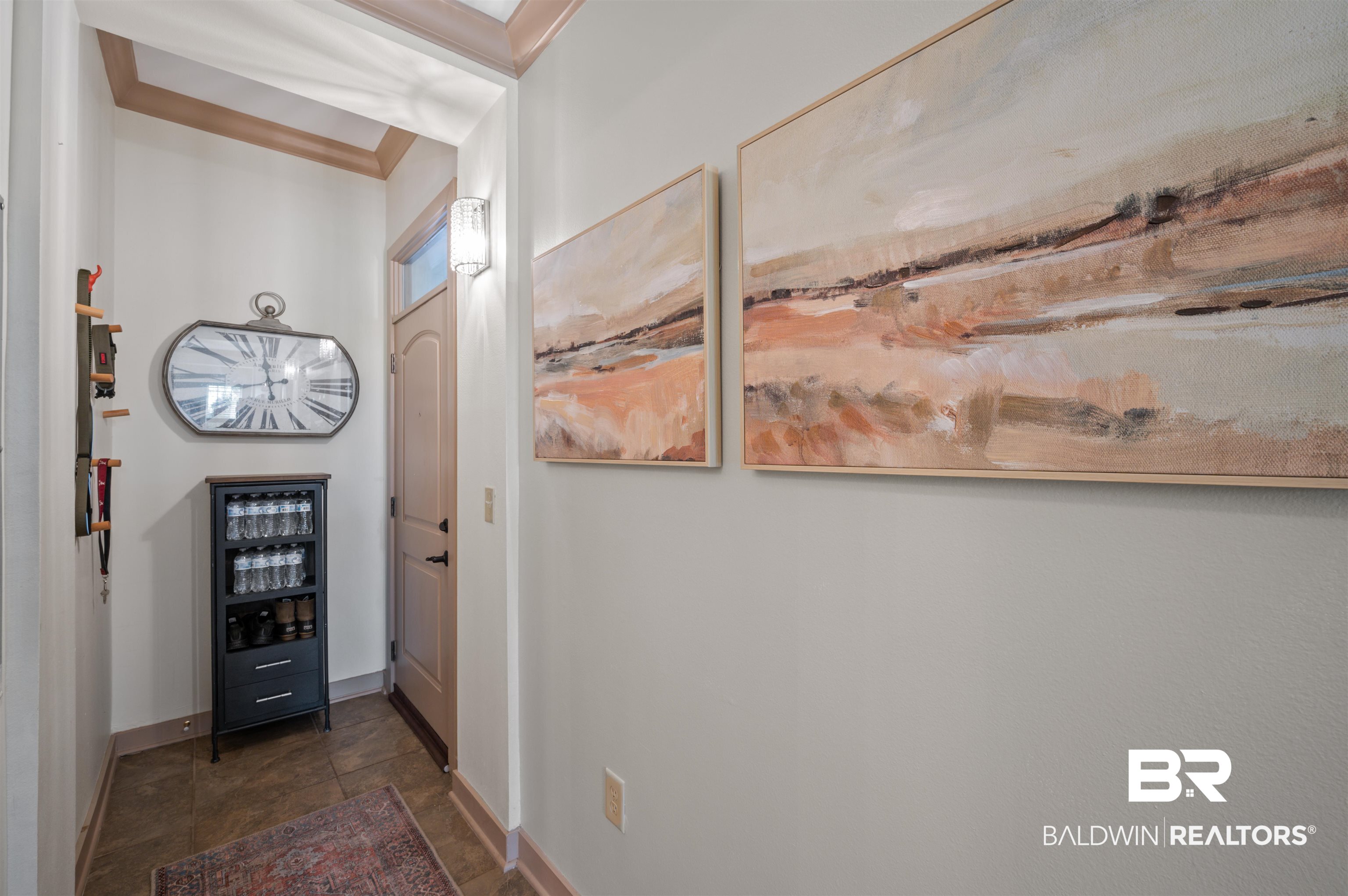 1430 Regency Road, Unit B202 Gulf Shores, AL 36542 - Photo 9 of 33 Interior space featuring dark tile patterned floors, baseboards, and crown molding